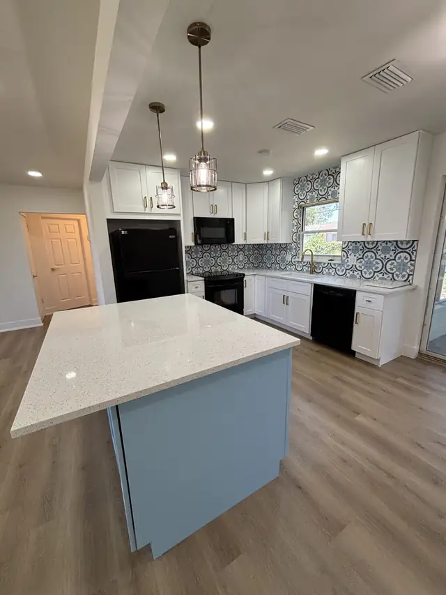 St. Petersburg kitchen remodel with a blue island, white quartz top, white shaker cabinets and patterned tile backsplash