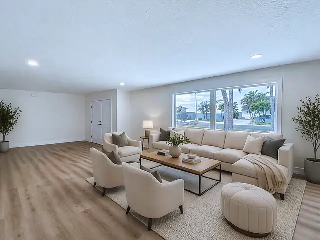 Whole-home remodel with open white kitchen, navy island, vaulted great room and new light vinyl plank floors